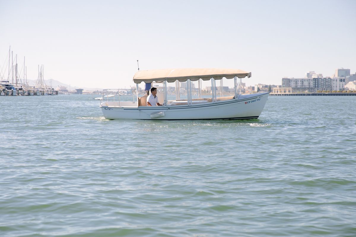 The Bae Boats Duffy Suncruiser electric boat with enclosed cabin and open deck on the Oakland Estuary in Alameda