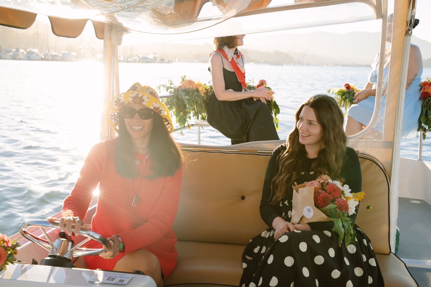 A group celebrating aboard a Bae Boats electric boat with food and drinks on the picnic table