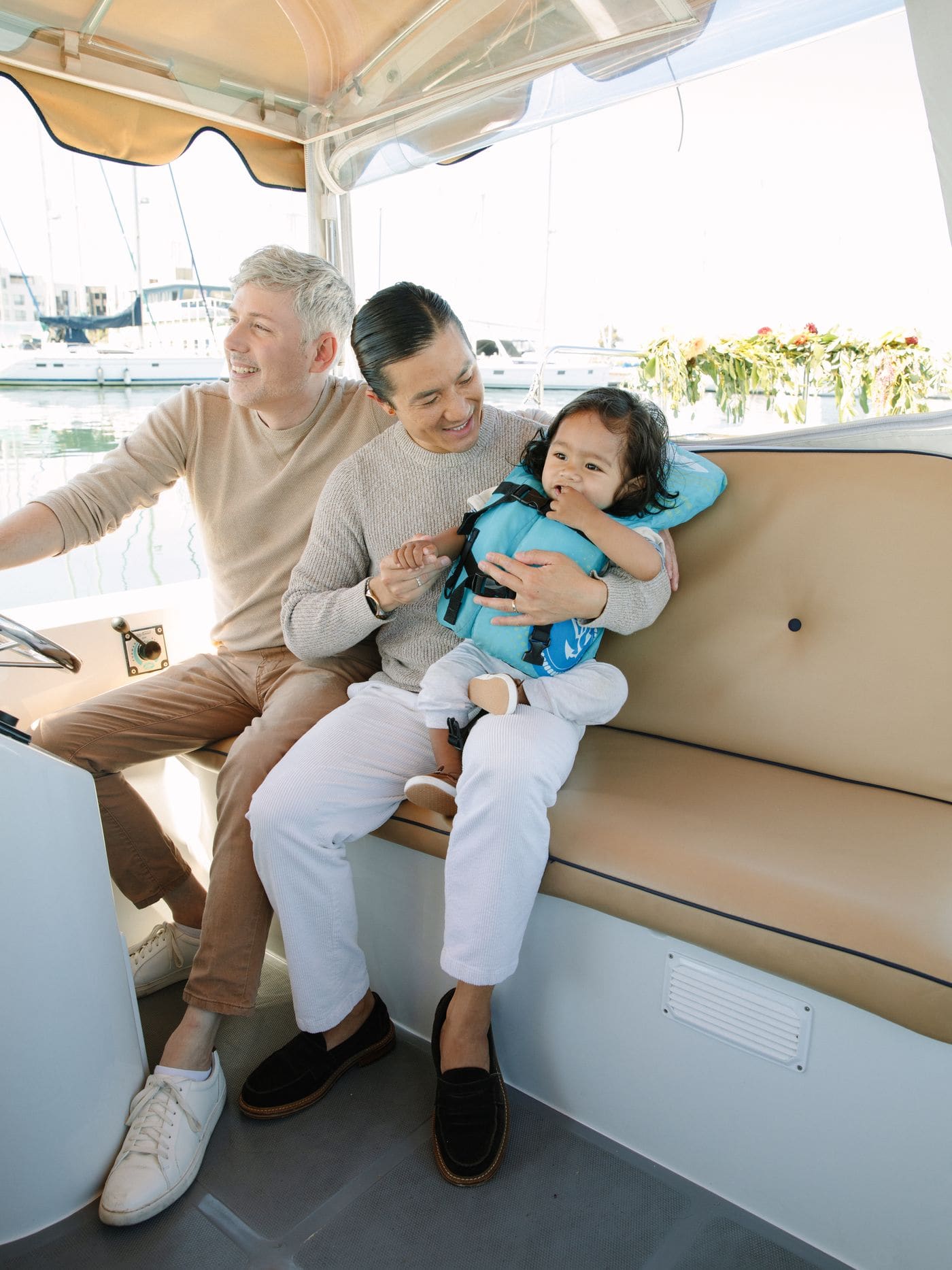 Guests relaxing aboard a Bae Boats electric boat on the Bay with food and drinks on the picnic table
