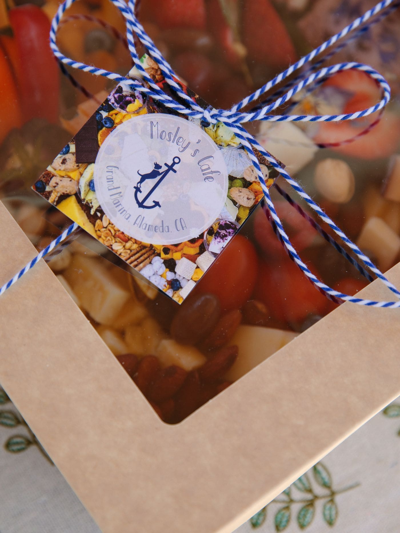 A Bae Boats gift card presented on the picnic table of an electric boat on the Bay