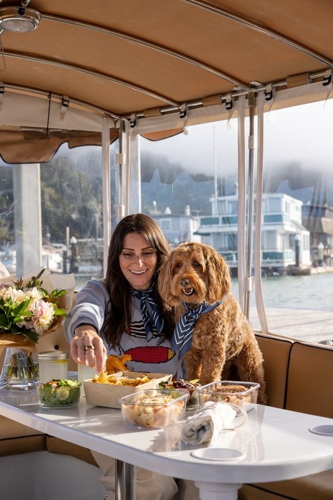 A dog aboard a Bae Boats electric boat on a Pup Package rental