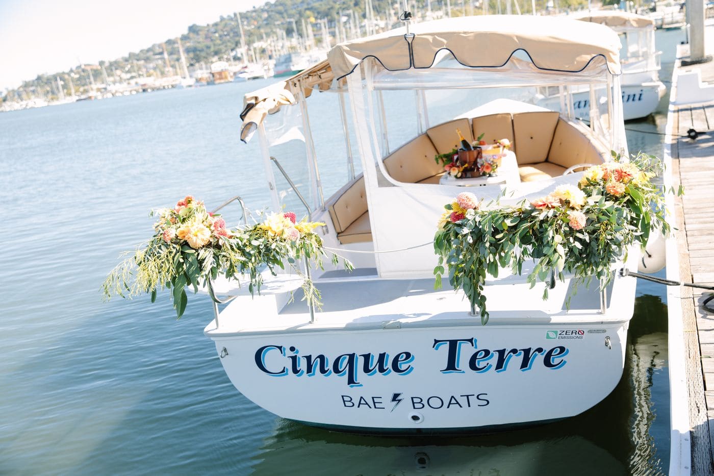 The Bae Boats electric Duffy boat Cinque Terre, dressed with flowers at the dock in Alameda