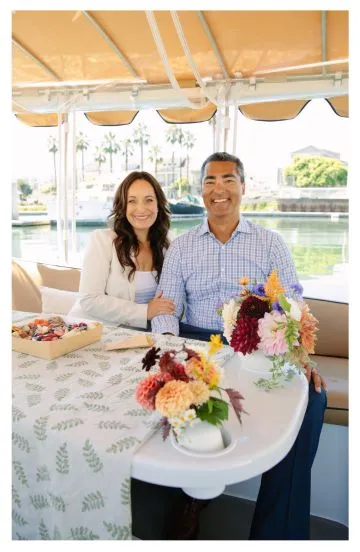 Guests aboard a Bae Boats electric Duffy boat on the Bay, with the shoreline behind